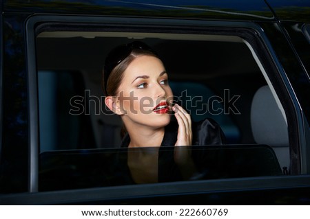 Sensual young woman looking out of a car window with parted lips and a look of anticipation