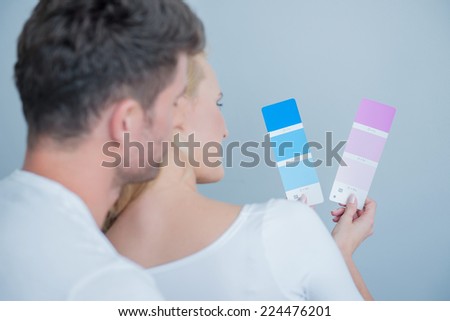 Close up Sweet Couples Looking at Colored Paper Together. Isolated on Light Blue Gray Background.