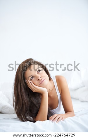 Close up Pretty Young Woman Lying in Bed with Hand on Face Doing Day Dreaming. Isolated on White Background.
