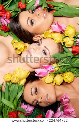 Close up Three Sensual Bare Woman on Fresh Roses Looking at Camera.