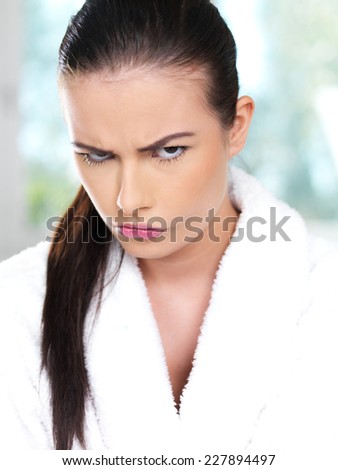 Angry young woman glowering under her eyebrows at the camera with a fierce expression