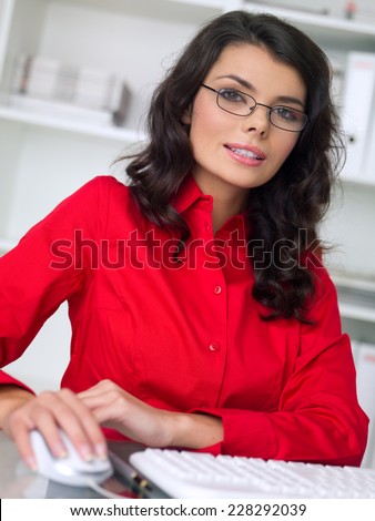 Close up Young Office Woman Wearing Red Blouse and Eye Glasses Working at her Table Area with Computer.