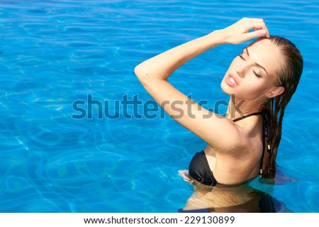 Close up Sensual Pretty Woman in Black Swim Wear Posing at Enchanting Swimming Pool on a Tropical Climate.