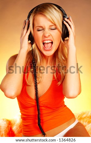 stock photo Sexy blond girl with black headphones close up on orange 