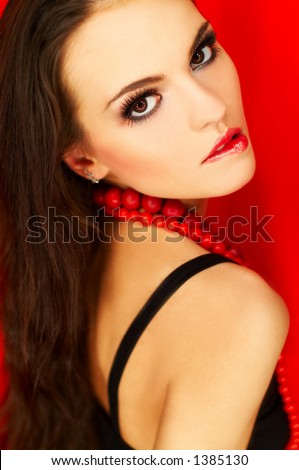 Portrait of attractive beautiful young sexy woman with black artificial eyelashes and red necklace