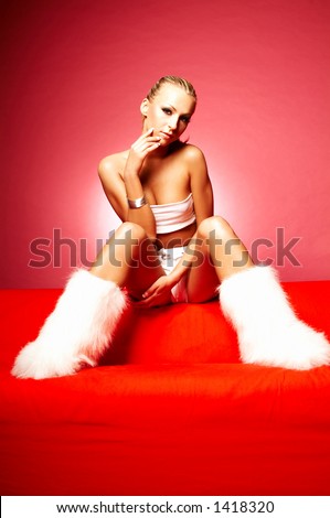 Portrait of young sexy women on red couch wearing white fur shoes