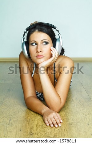  Young beautiful happy women listening music and wearing headphones
