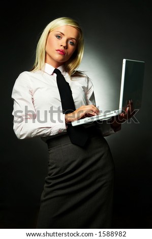 Young Business woman wearing white shirt and black tie using laptop computer