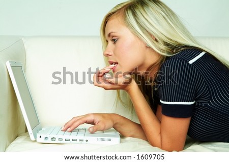 stock photo Young pretty women on white couch relaxing and using laptop 