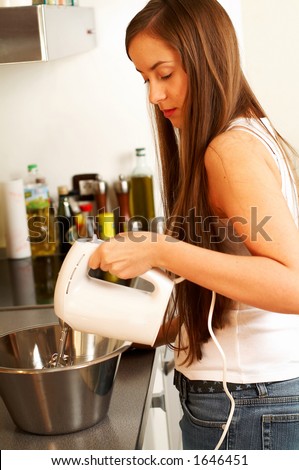 Young beautiful woman in kitchen with blender