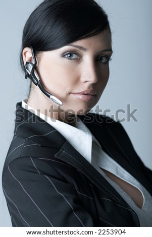 Beautiful brunette business woman with wireless headset isolated on clear background