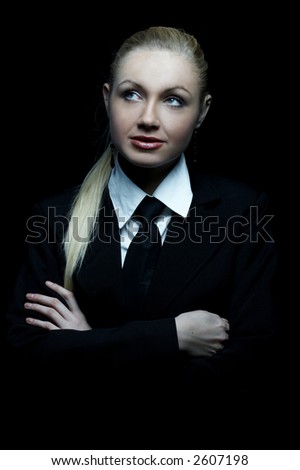 Beautiful business woman wearing black tie and jacket isolated on black background