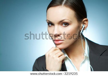 Beautiful and sexy brunette business woman isolated on clear background with headphones is listen to the music.