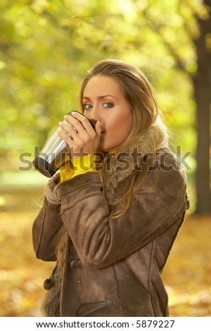 20-25 years old beautiful sexy woman portrait with hot coffee cup in natural autumn outdoors