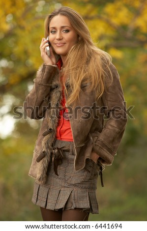 20-25 years old beautiful sexy woman portrait talking cell phone in natural autumn outdoors