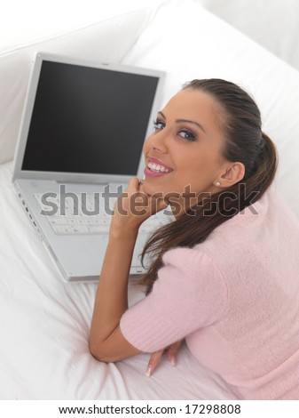Young pretty women on white couch relaxing and using laptop computer