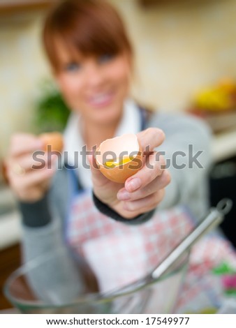 Beautiful woman in kitchen is making a cake