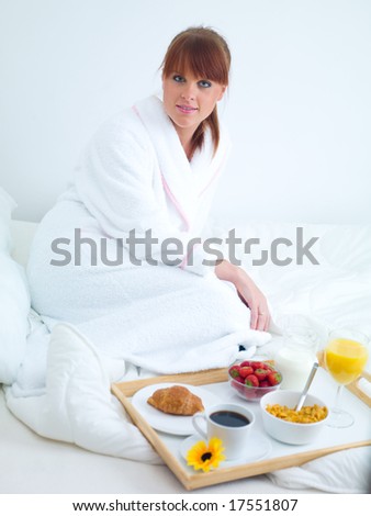 Beautiful woman eating breakfast in bed