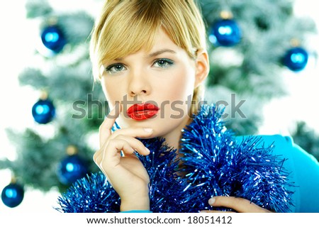 Beautiful young woman next to christmas tree on white background