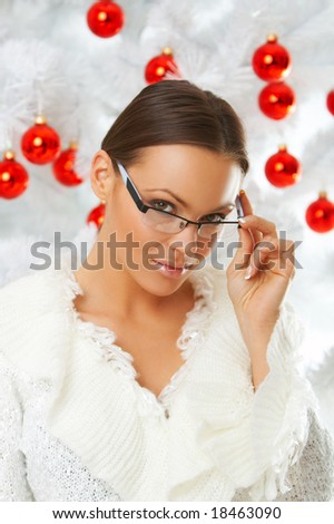 20-25 years old beautiful woman next to christmas tree on white background