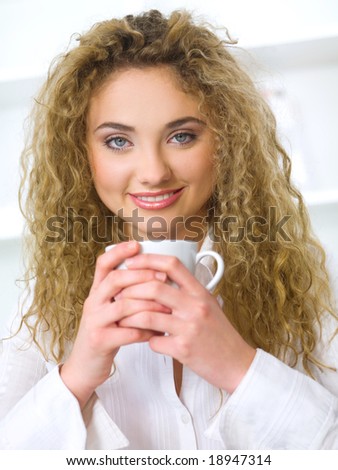 Beautiful business woman is drinking coffee in office