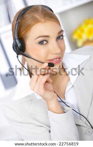 Blond business woman working in office, wearing headset