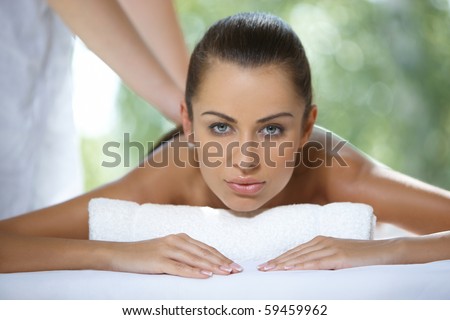 Beautiful woman is resting on spa bed