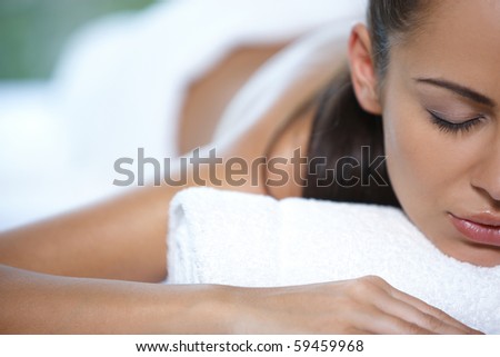 Beautiful woman is resting on spa bed
