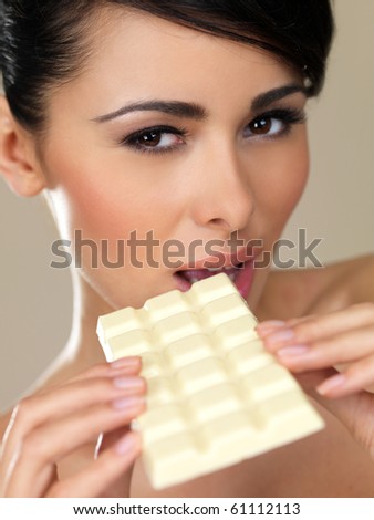 Portrait of beautiful woman, holding white chocolate bar