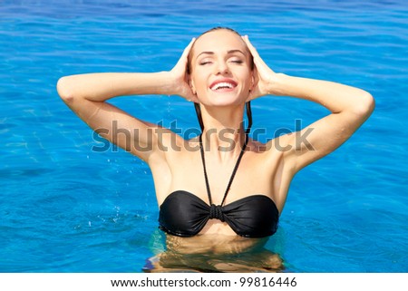Gorgeous woman raising her head out of the water in a swimming pool