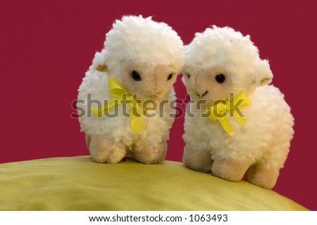 A cute spring picture of two toy sheep on a green hill.