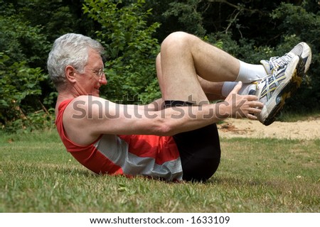 A senior man is stretching after a long run