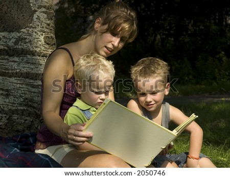 Family reading a book while on an outside trip