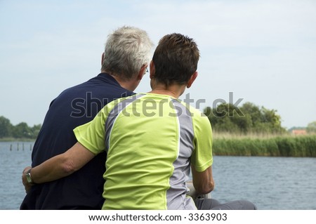 Senior couple sitting on a lonely place at a lake to think about their future and retirement.