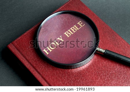 Loupe on a Bible. If  you\'re searching for answers, read it!