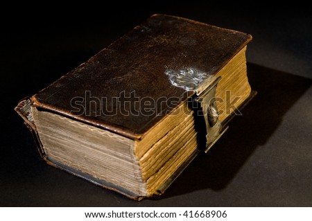 Nice old bible with an old lock on a black background.