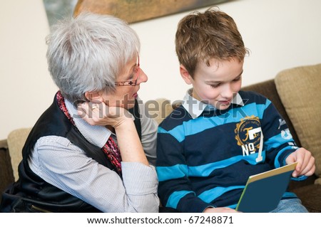 Grandma and grandson are reading a book.