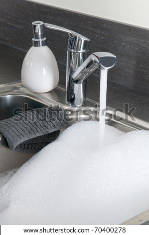 Closeup of a sink in a modern kitchen, ready to do the dishes.