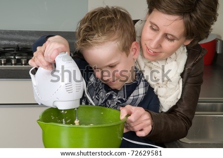 Mother and son are mixing the dough for the cake.
