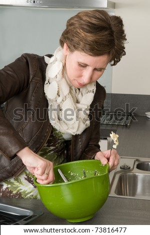 Woman in a kitchen busy with the dough for baking cakes.
