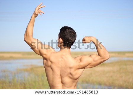 male bodybuilder model back view. outdoors background