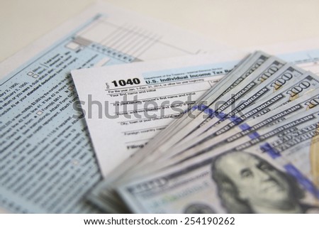 US Tax Form 1040 with new 100 US dollar bills. business concept
