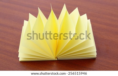 Block of yellow Post it Notes on a wood table