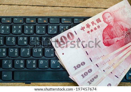 100 Taiwan Dollar bill on keyboard