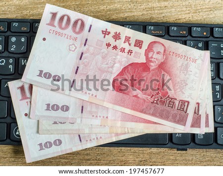 100 Taiwan Dollar bill on keyboard