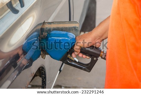 Hand refilling oil with car on gas station