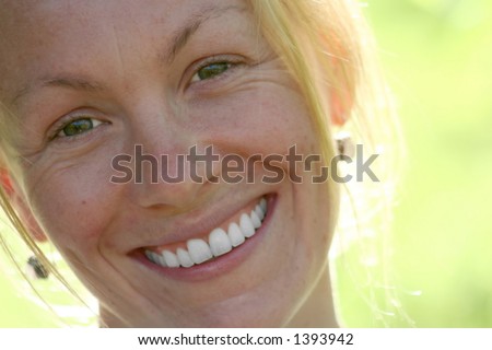 A portrait of a young woman\'s smiling face.