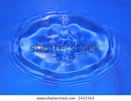 A drip of cool blue water rebounds upwards.
