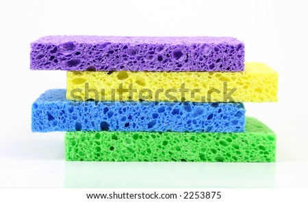 A stack of four colorful cleaning sponges against a white background.
