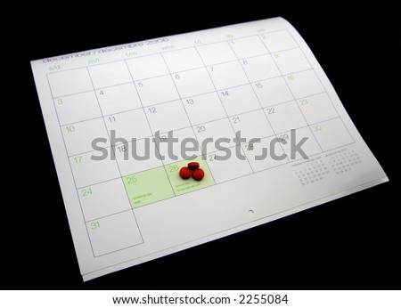 Three red headache pills sit on a calendar to highliight the stress of the holidays.